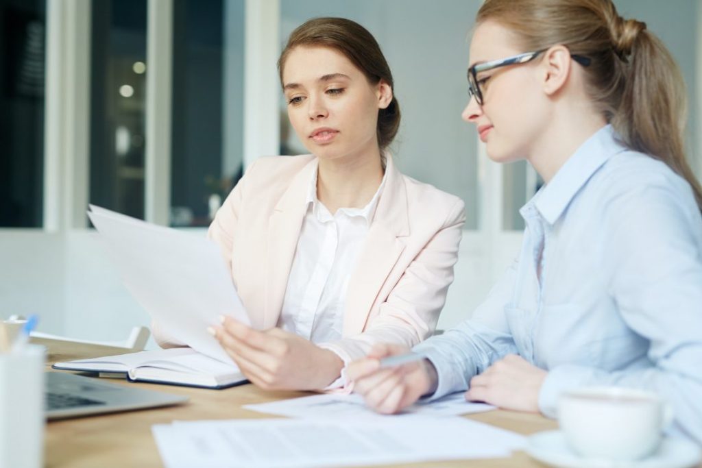 Two tax accountant in Ottawa sitting at a table and looking at papers.